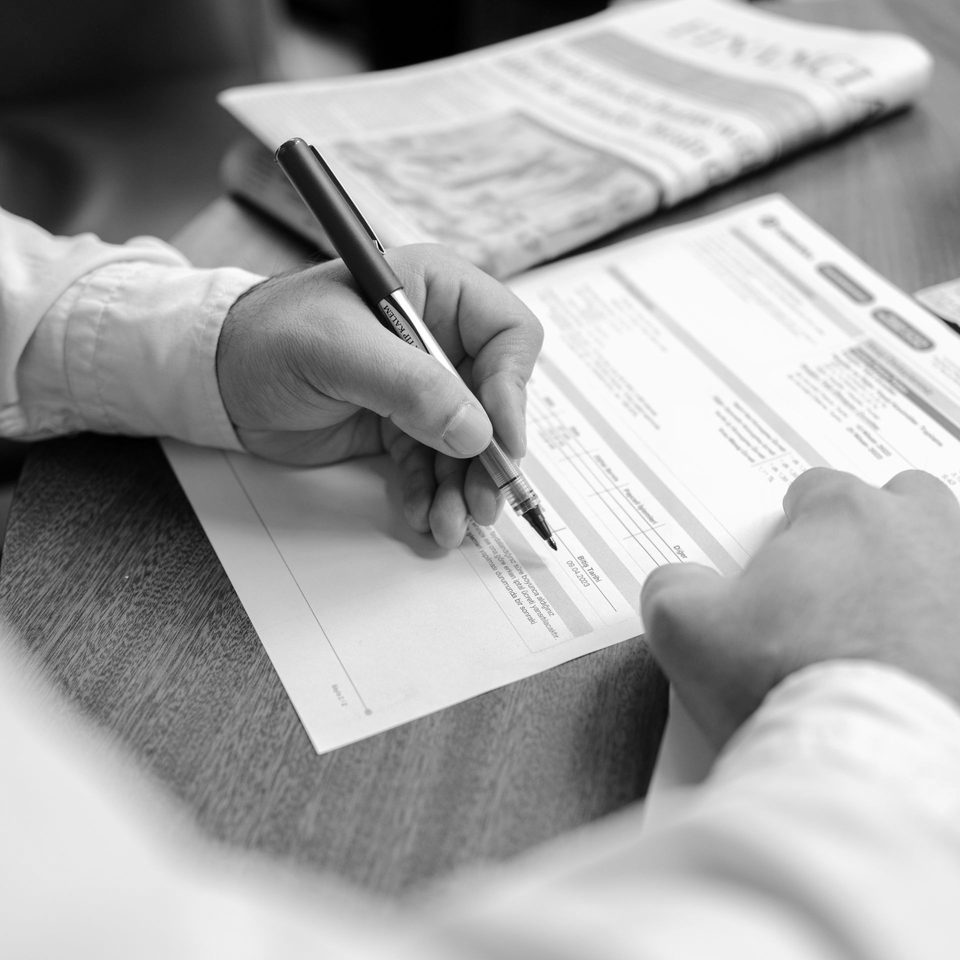 A person filling in a compliance document by hand