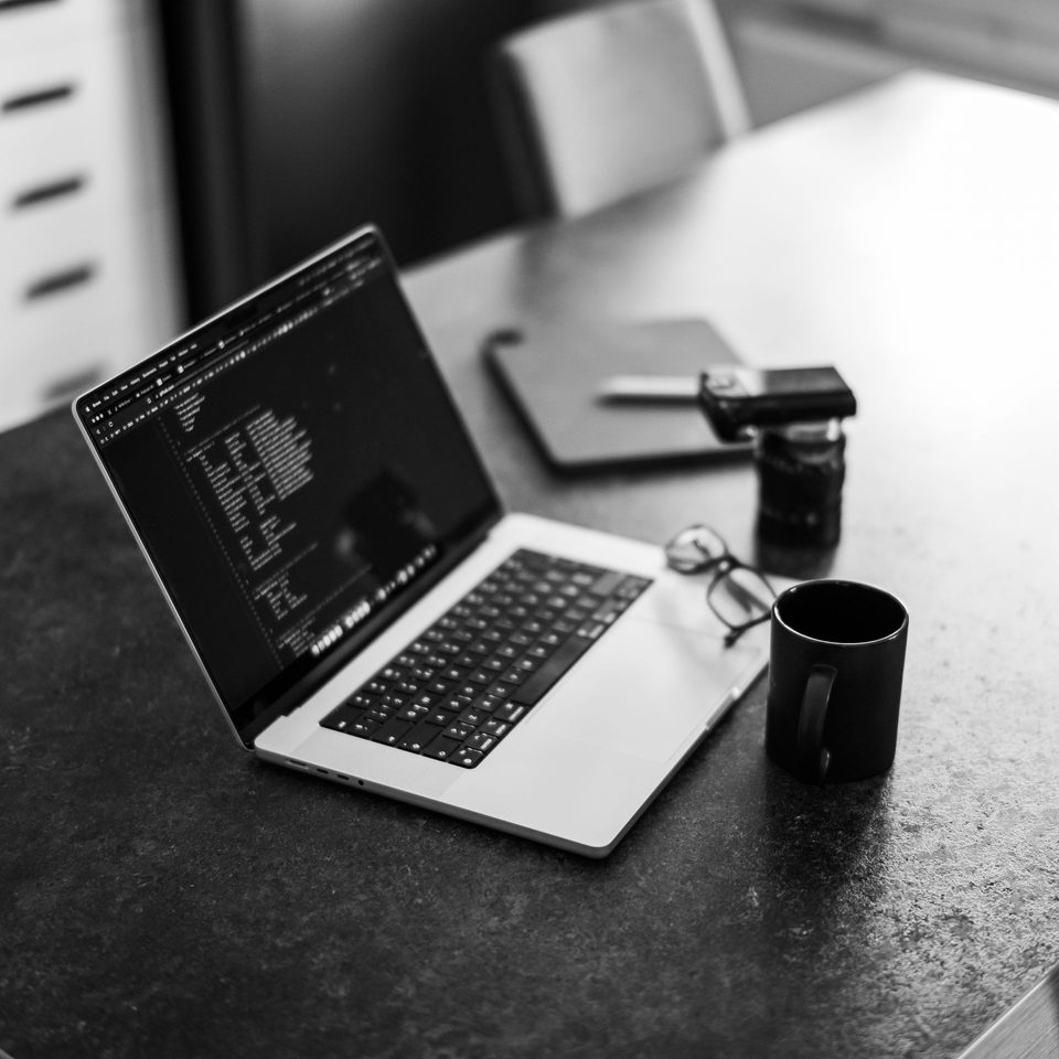 A laptop showing code, open on a desk
